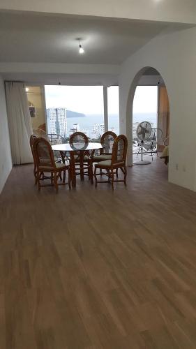 a dining room with a table and chairs in a room at Casa Horizonte Azul Acapulco in Acapulco
