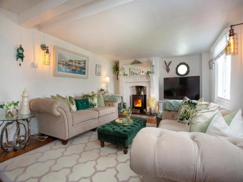 a living room with two couches and a fireplace at Spa Cottage in Mevagissey