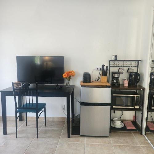 a kitchen with a table and a desk with a microwave at Cozy & Private Room in Goleta in Santa Barbara