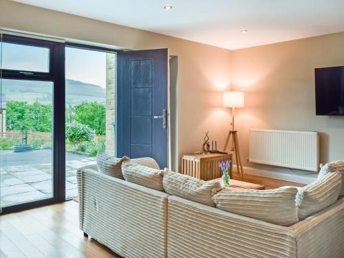 a living room with a couch and a sliding glass door at The Farmhouse Retreat in Millbrook