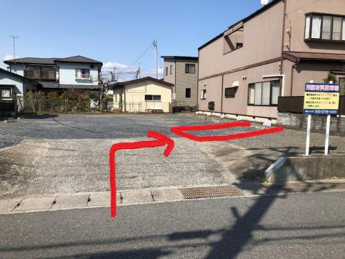 a red arrow in a parking lot next to a building at Private Room in Japanese Vintage House 民家の一室 Smoke Free, Free Parking Good to Travel for Tashiro Cats Island no1 in Ishinomaki