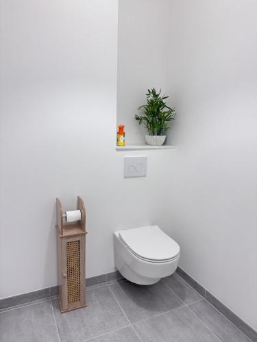 La salle de bains est pourvue de toilettes et d'une plante murale. dans l'établissement Just Sleeping, à Chessy