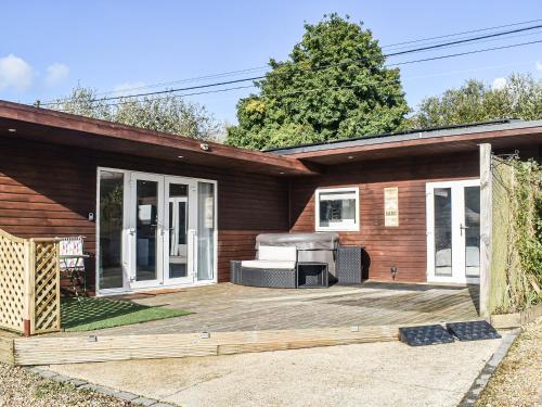 a house with a large patio with a grill at The Stables in Edmondsham