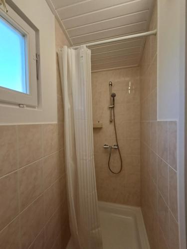 a bathroom with a shower with a shower curtain at Igali Varázs Apartman 150 méter a fürdőtől in Igal