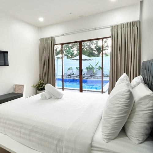 a bedroom with a bed with a view of a pool at Pineale Villas, Resort and Spa in Panglao