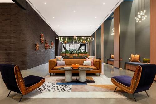a living room with a couch and a table and chairs at Luxury Apartments by Hyatus at Central Philly in Philadelphia