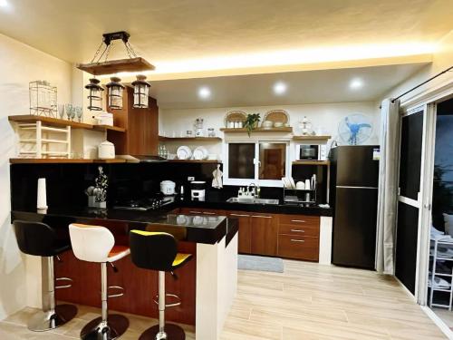 a large kitchen with a black refrigerator and cabinets at C&G Staycation Home in General Trias