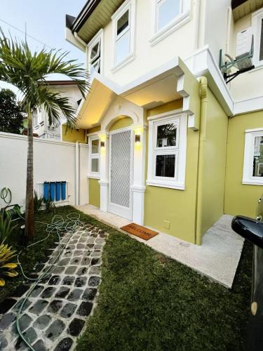 a yellow and white house with a garden at C&G Staycation Home in General Trias