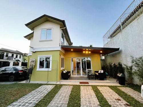 a yellow and white house with a patio at C&G Staycation Home in General Trias