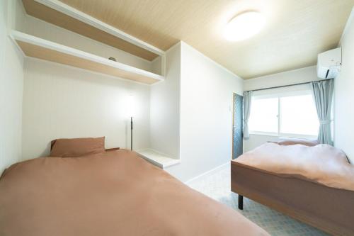 Postel nebo postele na pokoji v ubytování Hachiken House