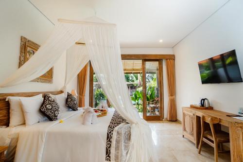 a bedroom with a white bed with a canopy at Kudesa Bali in Ubud