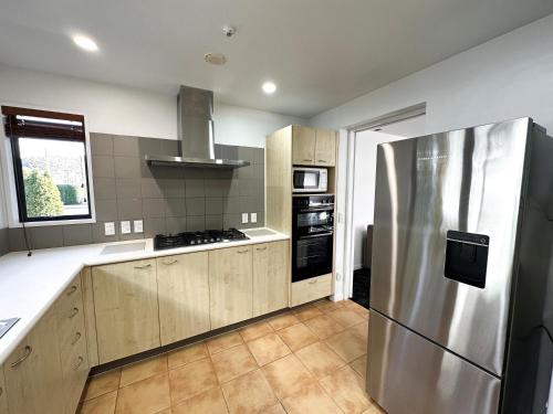 a kitchen with a stainless steel refrigerator and a stove at Delorenzo Studio Apartments in Nelson