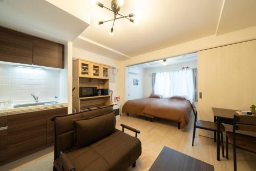 a bedroom with a bed and a kitchen with a couch at Laguna Verde Miyanosawa 102 in Sapporo