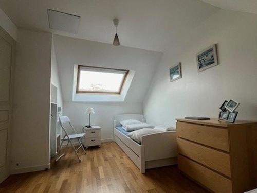 ein Schlafzimmer mit einem Bett, einer Kommode und einem Fenster in der Unterkunft Maison 7 pers, proche plage et centre Arzon, jardin calme - FR-1-775-33 in Arzon