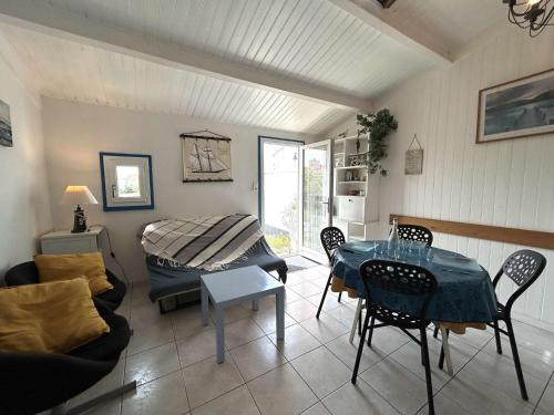 un salon avec une table et un canapé dans l'établissement Maisonnette avec piscine chauffée, proche mer - FR-1-224A-78, à Bretignolles-sur-Mer