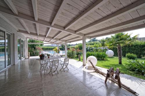 an outdoor patio with a table and chairs and a wooden ceiling at Hotel Country House La Radice in Civitanova Marche