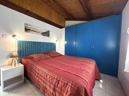une chambre avec des armoires bleues et un lit rouge dans l'établissement Maisonnette avec piscine chauffée, proche mer - FR-1-224A-78, à Bretignolles-sur-Mer