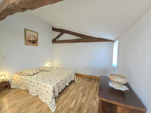 une chambre avec un lit et une table dedans dans l'établissement Charmant gîte en pierre avec piscine partagée, WiFi, proche de Bergerac - FR-1-616-490, à Lamonzie-Saint-Martin