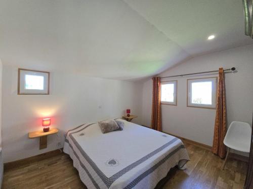 une chambre avec un lit et un bureau et deux fenêtres dans l'établissement Charmant Gîte en Périgord Pourpre avec Wifi et Terrasse Privée - FR-1-616-491, à Lamonzie-Saint-Martin