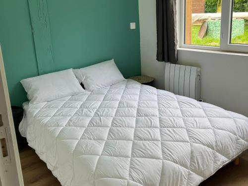 un grand lit blanc dans une chambre avec une fenêtre dans l'établissement Maison Vacances 4 Pers à Pontenx-Les-Forges - Proche Océan et Forêt - FR-1-50-185, à Pontenx-les-Forges