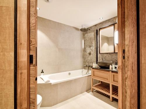 une salle de bain avec une baignoire et un lavabo dans l'établissement Chalet de location à Les Allues - FR-1-613-139, à Les Allues