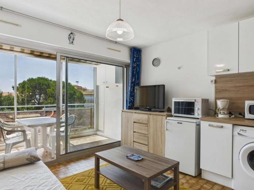 un salon avec une cuisine et un salon avec une table dans l'établissement Studio proche plage au Grau d'Agde, idéal famille - FR-1-423-328, au Grau-dʼAgde