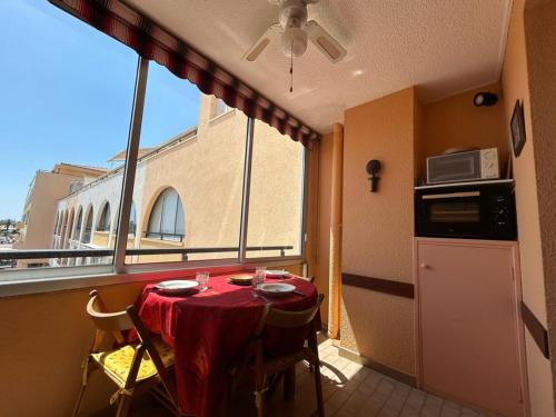 une petite cuisine avec une table et une fenêtre dans l'établissement Studio cabine avec loggia et parking, proche plage - FR-1-338-626, à Sète