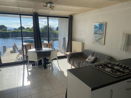 d'une cuisine et d'un salon avec vue sur l'eau. dans l'établissement Villa T4 vue lac avec ponton privé au Barcares - FR-1-782-80, au Barcarès