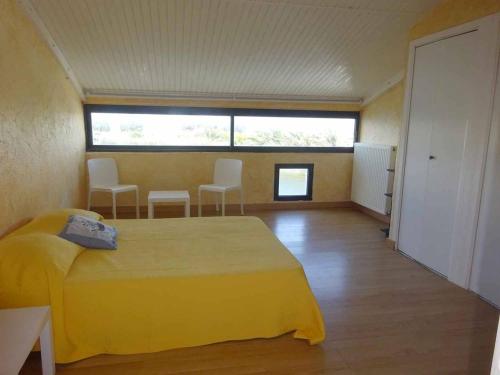 - une chambre avec un lit jaune et des chaises dans l'établissement Villa T4 vue lac avec ponton privé au Barcares - FR-1-782-80, au Barcarès