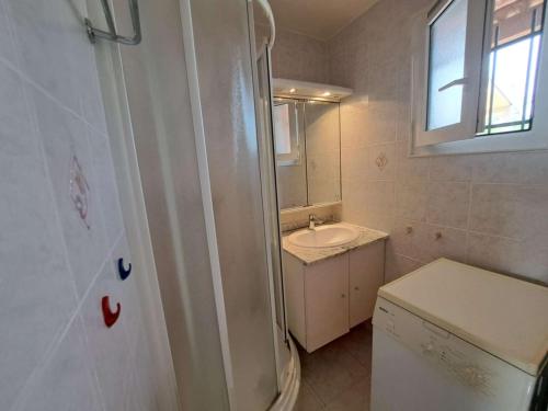 une salle de bain blanche avec un lavabo et une douche dans l'établissement Logement avec mezzanine, parking privé - Marseillan-Plage - FR-1-326-866, à Marseillan