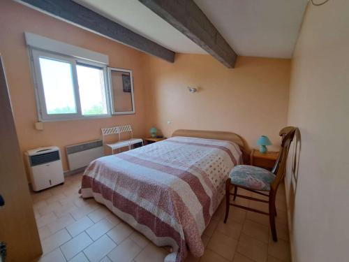 une chambre avec un lit, une chaise et une fenêtre dans l'établissement Logement avec mezzanine, parking privé - Marseillan-Plage - FR-1-326-866, à Marseillan