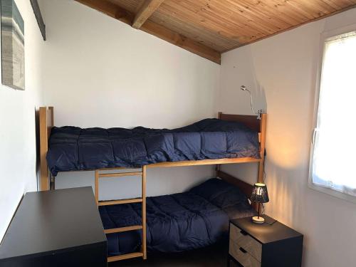 Cette petite chambre comprend des lits superposés et un bureau. dans l'établissement Maison rénovée 2 chambres, près mer, séjour TV - FR-1-224A-79, à Bretignolles-sur-Mer