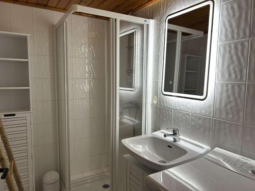 une salle de bain blanche avec un lavabo et une douche dans l'établissement Maison rénovée 2 chambres, près mer, séjour TV - FR-1-224A-79, à Bretignolles-sur-Mer