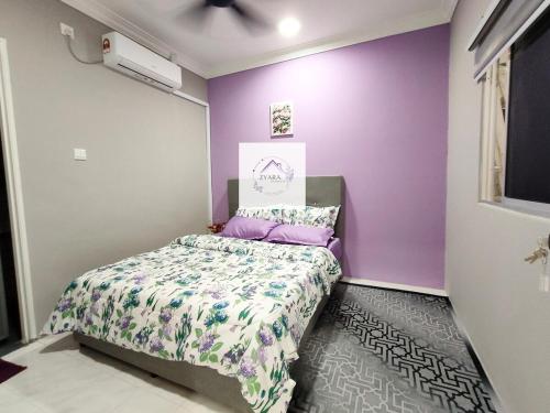 a small bedroom with purple walls and a bed at Zyara Homestay Seremban in Seremban