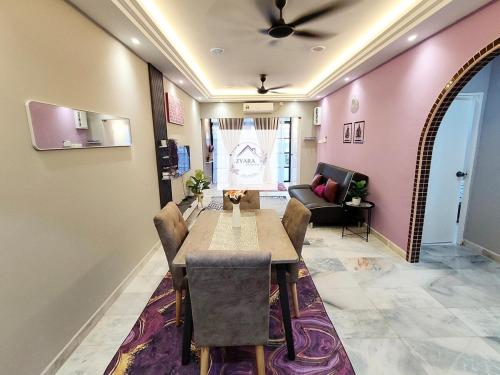 a dining room with a table and a couch at Zyara Homestay Seremban in Seremban