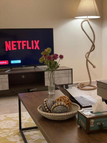 a living room with a table with a vase of flowers at شقق مسك الفندقية MISK Apartments in Riyadh Al Khabra