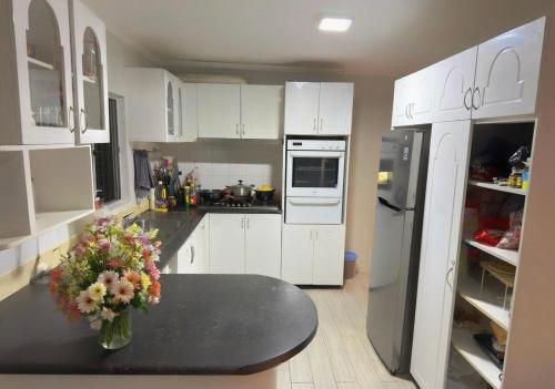 una cucina con un tavolo con un vaso di fiori sopra di Fiji Sky City近機場商圈可做飯有冷氣 a Nadi