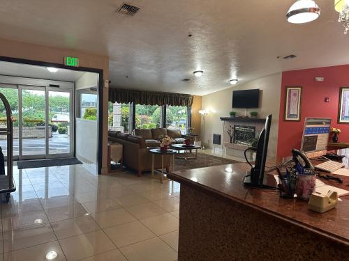 a living room with a couch and a fireplace at Bridgeway Inn & Suites - Portland Airport in Gresham