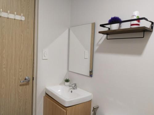 a bathroom with a sink and a mirror at Casa Linnea - SMDC Cheer Residences in Marilao