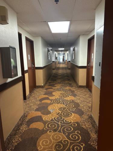 an empty hallway with a tile floor in a building at Bridgeway Inn & Suites - Portland Airport in Gresham