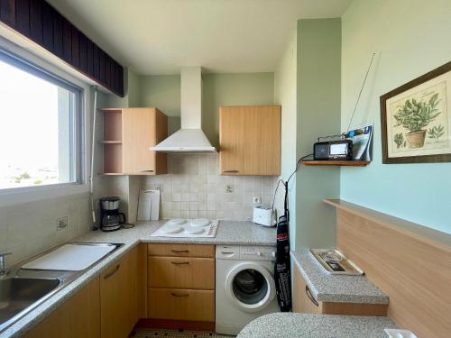 une petite cuisine avec un lave-linge. dans l'établissement Studio face mer avec balcon et garage aux Sables d'Olonne - FR-1-92-904, à Les Sables-dʼOlonne