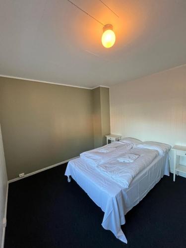a bedroom with a large bed with a white blanket at The Angler's House in Ballstad