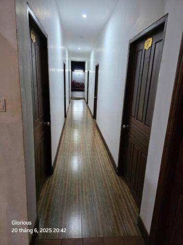 a hallway with two doors and a wooden floor at LuangPrabang Aurora Hostel in Luang Prabang