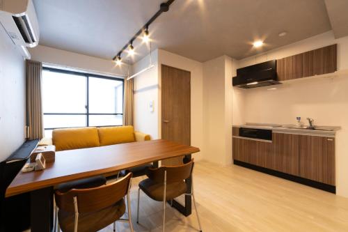 a kitchen and dining room with a wooden table and chairs at SLEEPLAB THE STAY Casual 池袋 -Ikebukuro- in Tokyo