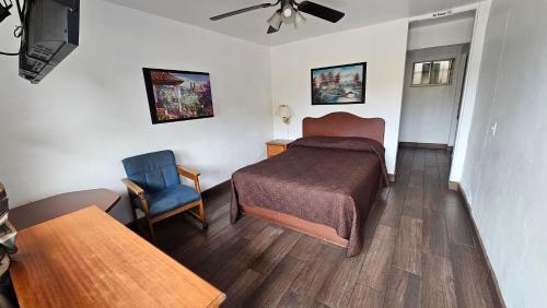 a hotel room with a bed and a chair at Motel Olvera in Tijuana