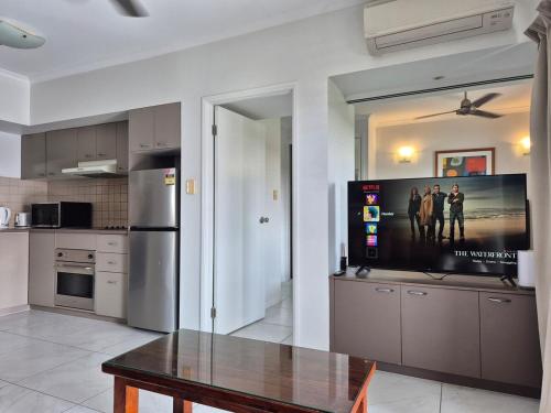 a kitchen with a table and a refrigerator at Cairns Central Atrium Apartments & Studio in Cairns