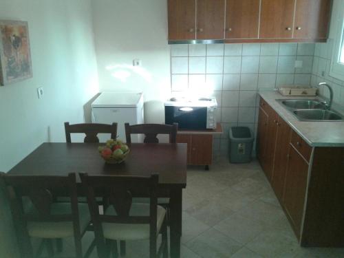 a kitchen with a table and chairs and a microwave at Georgia Apartments in Roda