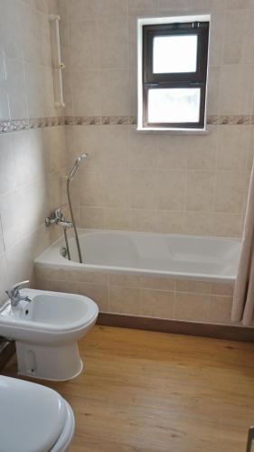 a bathroom with a tub and a toilet and a sink at Casa Tucano in Aljezur