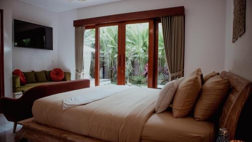 a bedroom with a large bed and a large window at Genta Villa Ubud, Great location in Ubud