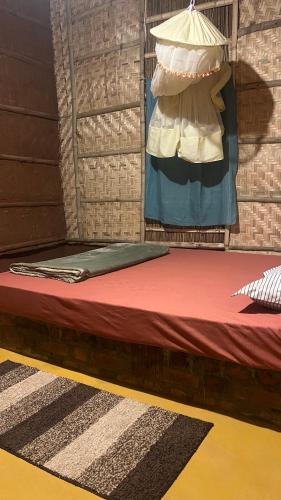 a bed in a room with a hanger with a bedsheet at Vanar Climbs Hampi in Hampi